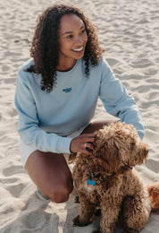 Lady wearing a plain embroidered sweatshirt, and its set on the beach.