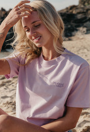 Lady wearing a plain embroidered t-shirt, and its set on the beach.