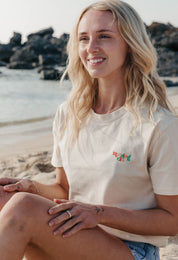 Lady wearing a plain embroidered t-shirt, and its set on the beach.