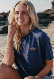 Lady wearing a plain embroidered t-shirt, and its set on the beach.