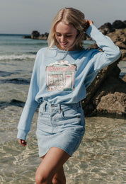 A lady wearing a printed cafŽ style printed sweatshirt, set by the sea.