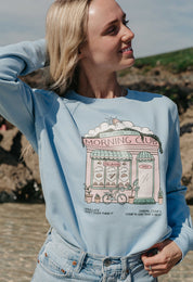 A lady wearing a printed cafŽ style printed sweatshirt, set by the sea.