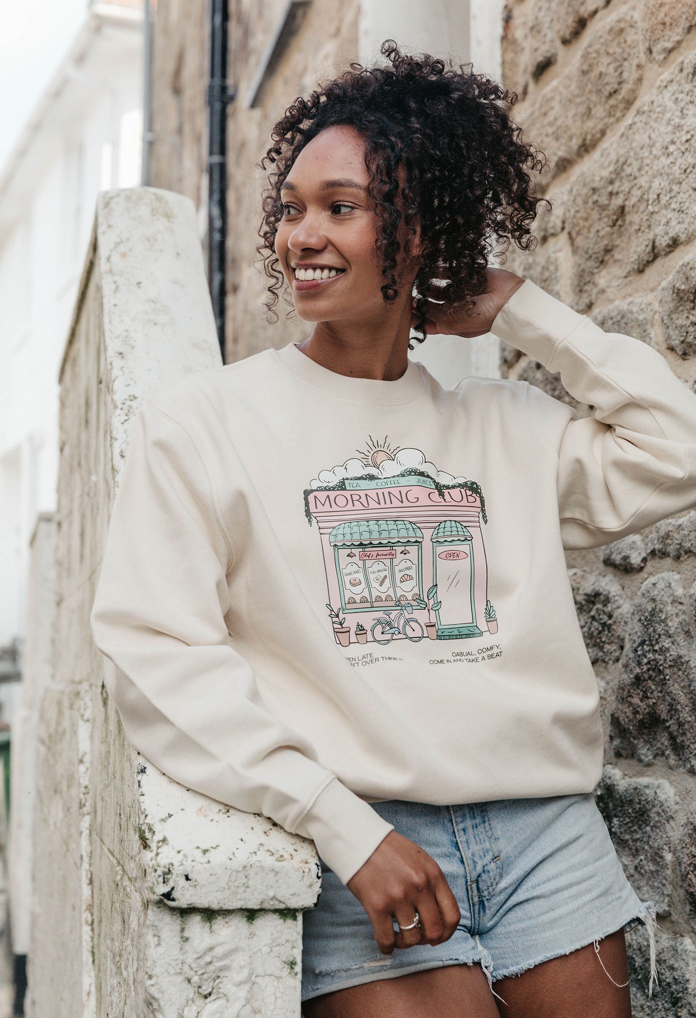 A lady wearing a printed cafŽ style printed sweatshirt, set by the sea.