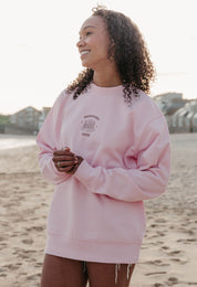 A lady wearing a printed pancake style printed sweatshirt, set by the sea.