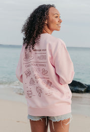 A lady wearing a printed pancake style printed sweatshirt, set by the sea.