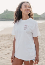 A lady wearing a white printed graphic t-shirt, with a illustration of a pancakes and toppings.